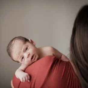 صورة لأم تحمل رضيعها المتألم