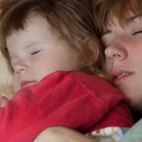 صورة طفل ينام بجانب أمه