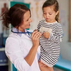 صورة طبيبة تداعب الطفلة