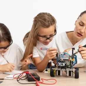 معلمة تساعد طالبتين في بحثهما العلمي