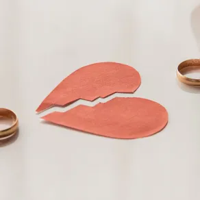 زوجان بينهما قلب مكسور كل منهما يمسك خاتمه علامة الانفصال حيث تلاشي المشاعر الرومانسية والاهتمام اليومي، يؤدي لانهيار الثقة وتصدع الحياة الزوجية - المصدر: freepik زوجان بينهما قلب مكسور كل منهما يمسك خاتمه علامة الانفصال