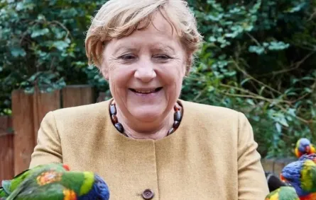 تطعم الببغاوات ذات الألوان الزاهية التي ترفرف حولها-  الصورة من وكالة الأنباء الألمانية د.ب.أ