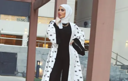 زهراء أشكناني بعباية بأكمام عريضة باللونين الأبيض والأسود مطبعة بالرسوم 