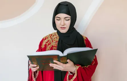 سيدة تمسك بمصحف شريف تتلو آيات من القرآن الكريم