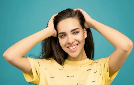 فتاة تبدو واثقة من نفسها وهي تبتسم بسعادة