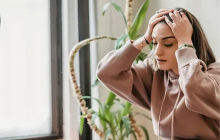 شابة تواجه الانتقادات بضيق وترفع يديها فوق رأسها  