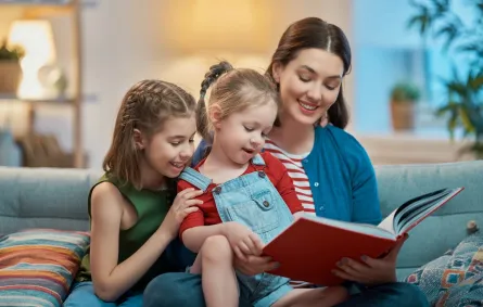 صورة لأم تقرأ قصة لطفلتيها
