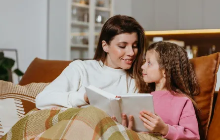 صورة لأم تقرأ لطفلتها