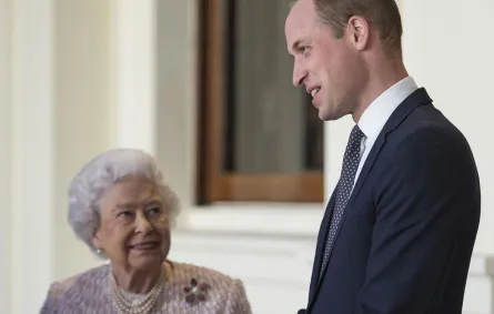 الملكة إليزابيث الثانية مع حفيدها الأمير ويليام بقصر باكنغهام في وسط لندن (Queen Elizabeth II with her grandson Prince William outside the Grand Entrance of Buckingham Palace in central London). مصدر الصورة: Victoria Jones / POOL / AFP