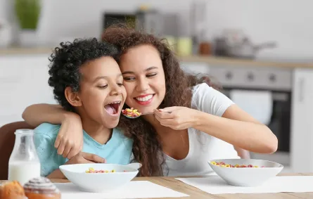 صورة لأم تُطعم طفلها بمرح