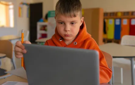 طفل يجلس أمام الكمبيوتر 