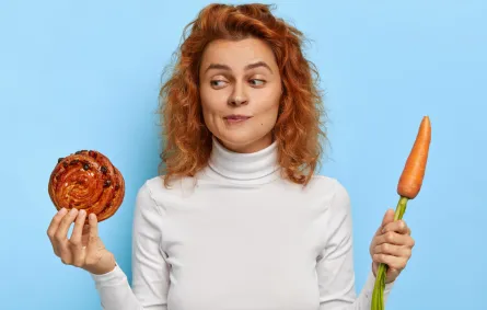 سيدة حائرة بين تناول الخضار أو الحلوى- المصدر freepik