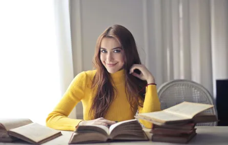 شابة تقرأ عدداً من الكتب في إدارة الأعمال والقيادة 