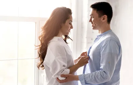 زوجة تهندم ملابس زوجها بمحبة