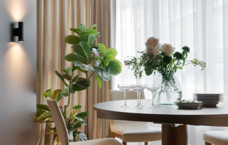 غرفة طعام مودرن مع إضاءة حائطية وزينة عبارة عن شجرة تين الكمان