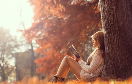 شابة تقرأ رواية في الطبيعة