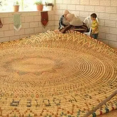 مسنة فلسطينية تنتهي من صناعة أكبر صينية قش في العالم