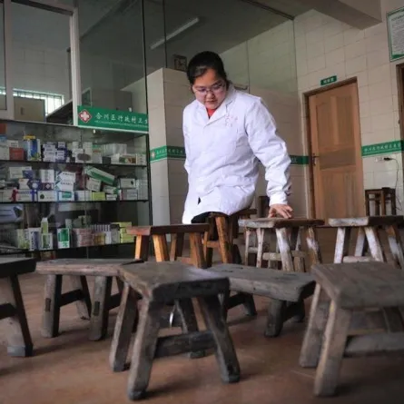 طبيبة صينية بلا رجلين تتنقل لعلاج مرضاها بكرسيين خشبيين