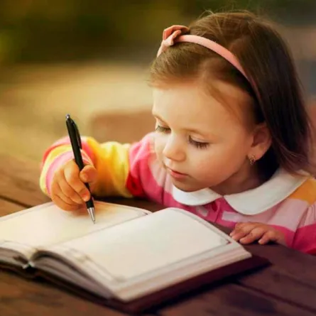صورة لطفلة مع الورق والقلم
