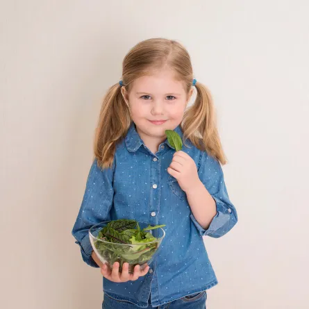 صورة لطفلة تتناول السبانخ