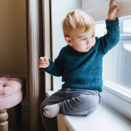 صورة لطفل يتسلق على النافذة