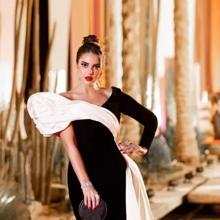 درة بفستان أنيق باللون الأسود بتصميم ذي وشاح أبيض أنيق 