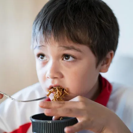 طفل يأكل النودلز بصوص الصويا