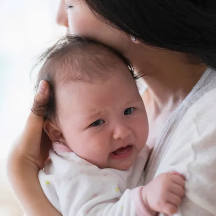 صورة لأم تحاول تهدئة طفلها 