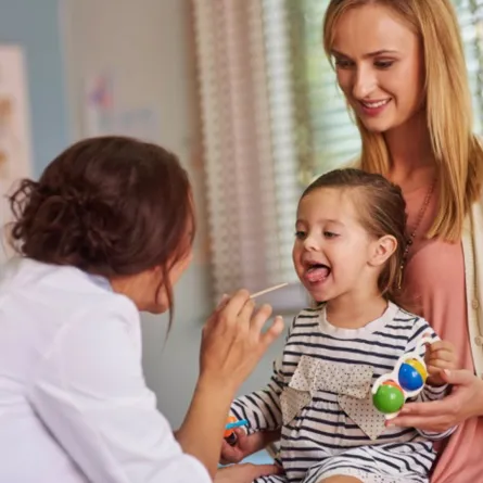 صورة  لطبيب يقوم بفحص التهاب اللوزتين 