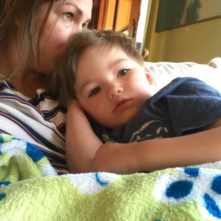 صورة لأم تحتضن طفلها المريض