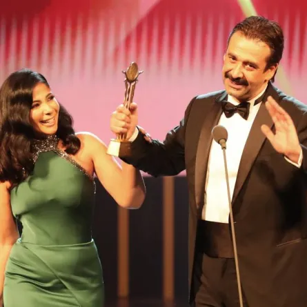 منى زكي وكريم عبد العزيز لحظة تكريمه بجائزة فاتن حمامة - الصورة من المركز الإعلامي لمهرجان القاهرة السينمائي