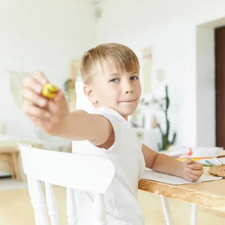 صورة لطفل يعرض قطع الصلصال التي صنعها