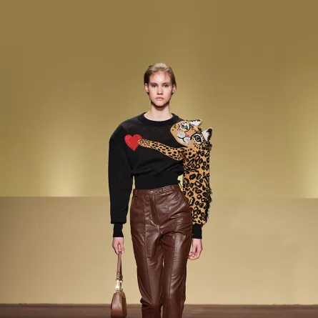 تنسيق بنطلون جلد واسع بني مع تيشرت بأكمام طويلة أسود مطبع بقطة كبيرة