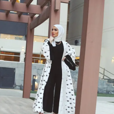زهراء أشكناني بعباية بأكمام عريضة باللونين الأبيض والأسود مطبعة بالرسوم 