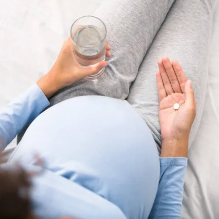 صورة لحامل تتناول المكملات الغذائية