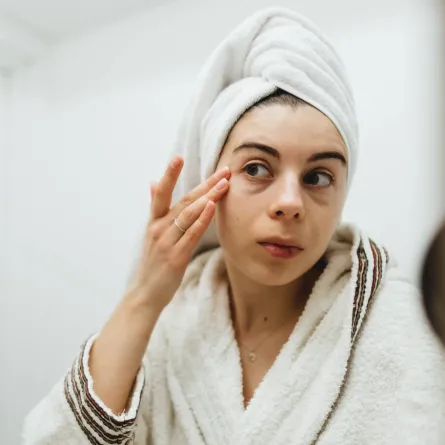 صورة لامرأة تتفقد بشرتها