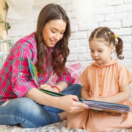 صورة الأم تقرأ لطفلتها