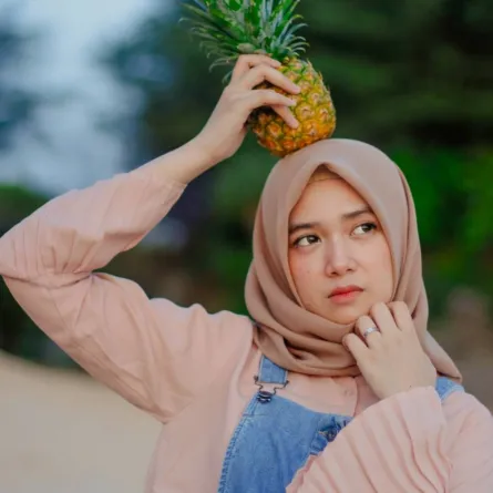 صورة لحامل تحمل ثمرة الأناناس