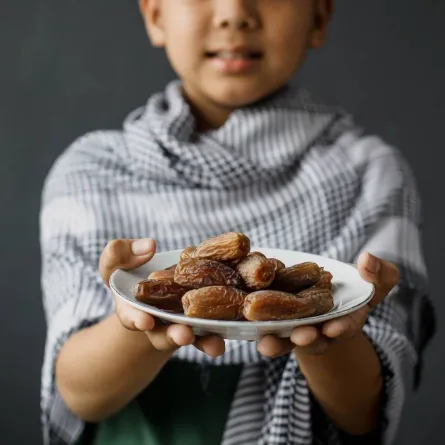 صورة لطفل يحمل التمر