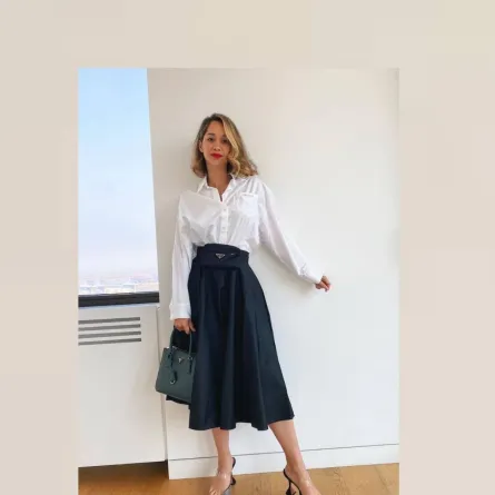 لانا الساحلي بقميص أبيض وتنورة ميدي سوداء وحقيبة خضراء من برادا