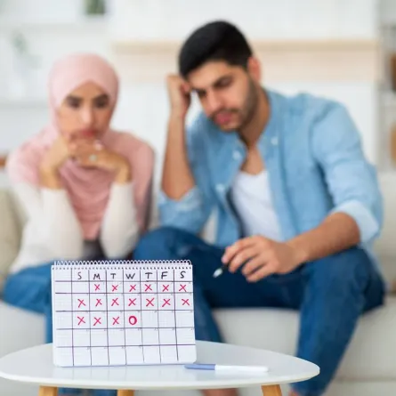 صورة لزوجين يتابعان جدول أيام الحمل