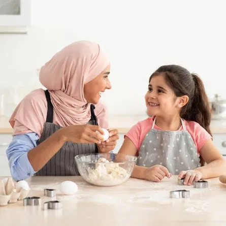 صورة لأم تعد حلويات العيد مع أطفالها