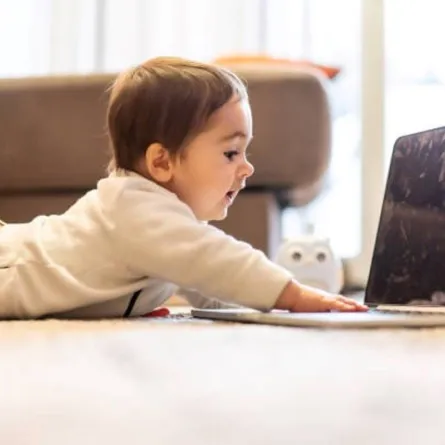 صورة لطفل تحت السنتين أمام شاشة مضيئة