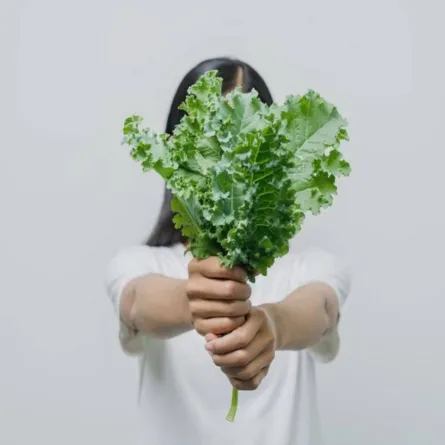 صورة لحامل تمسك بالخضروات الورقية