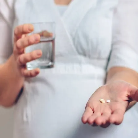 صورة لامرأة حامل تتناول مكملات الحديد