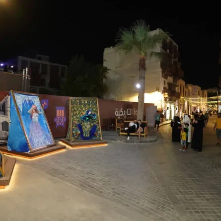 عدد من الزوار أمام الرسمة الحية