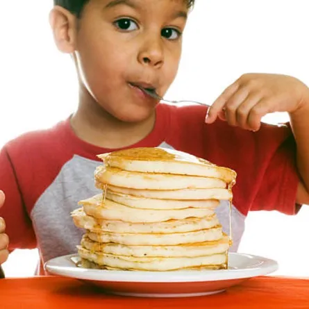 صورة لطفل يلتهم البان كيك