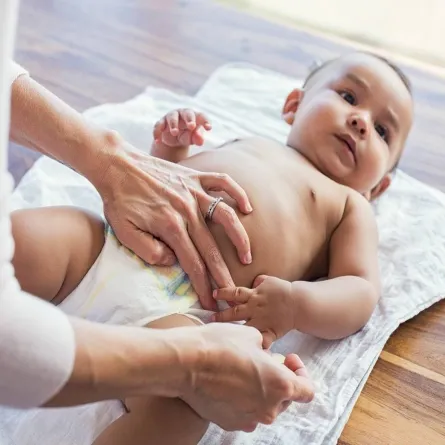 صورة لأم تغير حفاض طفلها