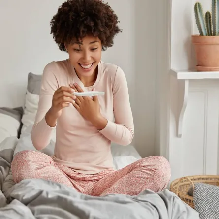 صورة لامرأة تحمل اختبارَ حمل منزلياً