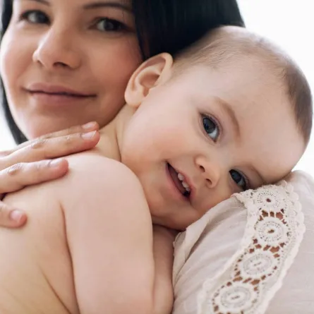 صورة لطفل يبتسم على كتف أمه